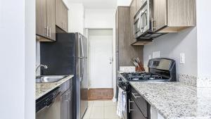 a small kitchen with a stove and a sink at Landing Modern Apartment with Amazing Amenities (ID9104X34) in Alexandria