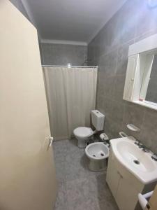 uma casa de banho com um WC branco e um lavatório. em Depto Latorre em General Pico