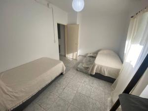 a bedroom with two beds and a tiled floor at Depto Latorre in General Pico
