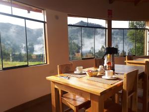 einen Tisch mit Kaffeemaschine in einem Zimmer mit Fenstern in der Unterkunft Huaraz Lodge and Bungalows in Huaraz