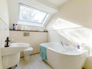 a bathroom with a tub and a toilet and a window at 3 Bed in Wetton 79554 in Wetton