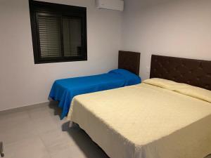 ein Schlafzimmer mit zwei Betten und einem Fenster in der Unterkunft Hermoso dpto. Zona céntrica in Santiago del Estero