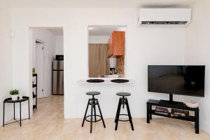 a kitchen with a counter and stools in a room at Casa Luquillo in Fajardo