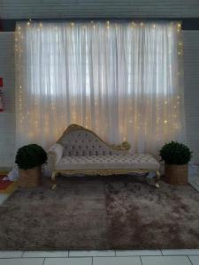 eine weiße Couch vor einem weißen Vorhang in der Unterkunft Espaço Festas Eventos Corporativos in Balsa Nova