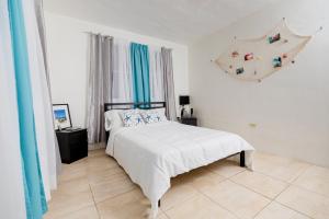 a bedroom with a bed in a white room at Casa Luquillo in Fajardo
