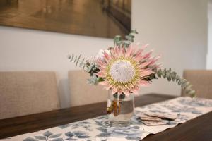 een vaas gevuld met roze bloemen zittend op een tafel bij Hamptons House Mudgee -Lux Stays in Mudgee