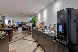 a restaurant with a bar with a coffee machine at Hotel Slavieiro Moema Suite Prime Familia in Sao Paulo