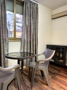 a room with a table and two chairs and a window at LB Apartments in Tirana