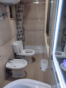 a bathroom with two toilets and a sink at LB Apartments in Tirana