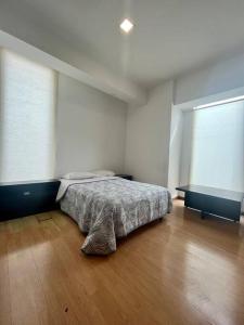 una camera con letto e pavimento in legno di La mejor opción Departamento Senza 3 a El Gallinero