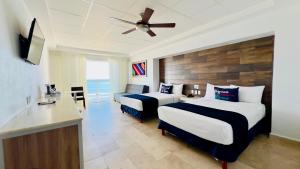 a hotel room with two beds and a ceiling fan at Hotel Villa Varadero in Nuevo Vallarta 