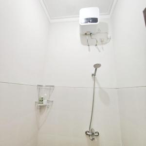 a shower in a white bathroom with a shower at Kayana Regency F7 in Batu