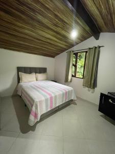 a bedroom with a bed with a wooden ceiling at Pousada Recanto Verde in Sana