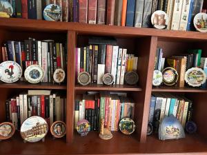 a book shelf filled with books and clocks at Quien lo vive es quien lo goza in Barranquilla