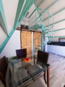 a dining room with a glass table and a spiral staircase at Cabaña puente Wilson in Alto Boquete