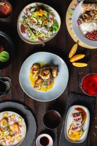 a wooden table with plates of food on it at Villa Blanca Cloud Forest Hotel & Retreat in San Ramón