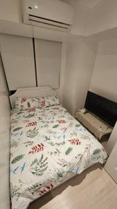 Dormitorio pequeño con cama con edredón blanco en Above the SKY getaWAY, en Manila
