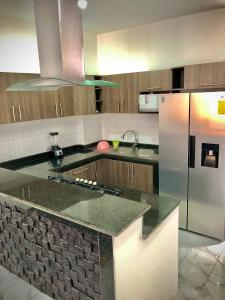 uma cozinha com um balcão de granito e um frigorífico em Casa cerca del Terminal de SANTO DOMINGO em Santo Domingo de los Colorados