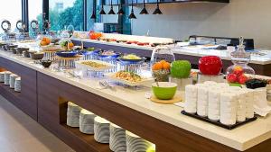 una línea de buffet con platos y comida a la vista en Jeju Hotel the M, en Seogwipo