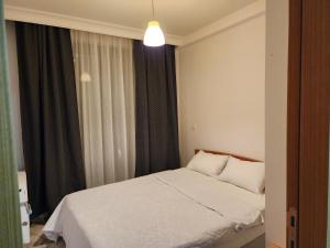 um quarto com uma cama branca e uma janela em TAKSiM SQUARE PERFECT FAMILY RESIDENCE WITH POOL em Istambul
