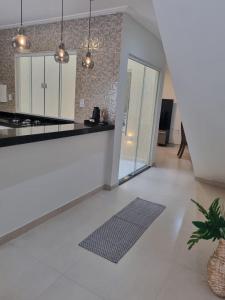 - une cuisine avec un sol blanc et un comptoir dans l'établissement Villa do Aconchego apartamento super novo, à Búzios