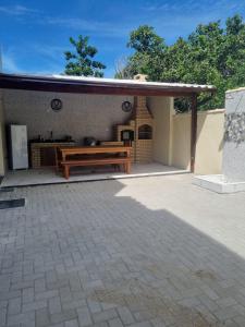 um pátio com um banco de madeira e uma mesa em Villa do Aconchego apartamento super novo em Búzios