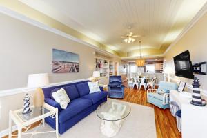 a living room with a blue couch and chairs at The Carolina Shell in Ocean Isle Beach