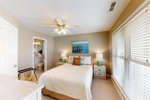 una camera con letto e ventilatore a soffitto di The Carolina Shell a Ocean Isle Beach