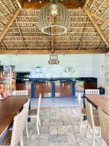 une cuisine avec des tables et des chaises en bois et un plafond dans l'établissement AP alto da serra Villas 104A, à Bananeiras