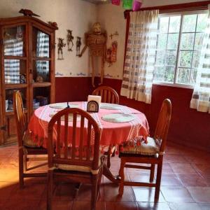 Oaxaca Deleite في مدينة أواكساكا: غرفة طعام مع طاولة وكراسي وتمثال