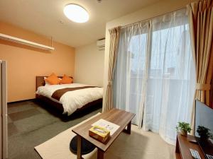 a bedroom with a bed and a large window at Calm Stay Nijo in Kyoto