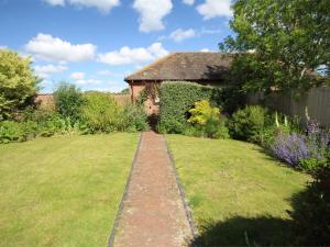 a garden with a brick path in front of a house at 3 Bed in East Stoke DC106 in East Stoke
