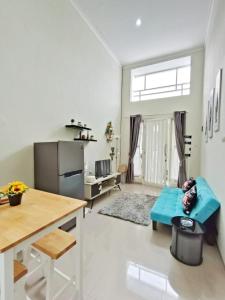 a kitchen and living room with a couch and a table at Kayana Regency F7 in Batu