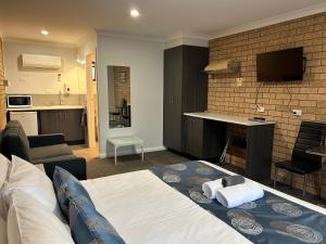 1 dormitorio con 1 cama y sala de estar en Motel Woongarra en Rutherglen