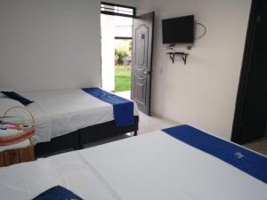 a room with two beds and a tv in it at Cosmos Tatacoa Hotel in Villavieja