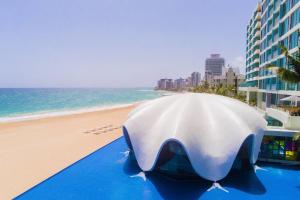 a large white tent on the beach next to a building at La Concha Renaissance San Juan Resort in San Juan