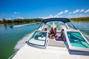 a group of people sitting on a boat on the water at Pousada Iguatiba in Paraibuna