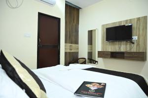 GulzārbāghにあるHotel Glance Innのベッドルーム1室(ベッド1台、壁掛けテレビ付)