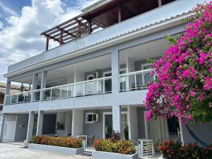 un edificio con flores rosas delante de él en Mar Y Suites, en Cabo Frío