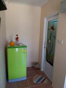 a green refrigerator in a corner of a room at ํYada Resort Koh Yao Noi in Ko Yao Noi