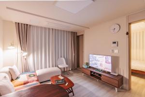 ソウルにあるStaylim - Seoul Botanic Park, Airportの広いリビングルームが備わるホテルルームです。