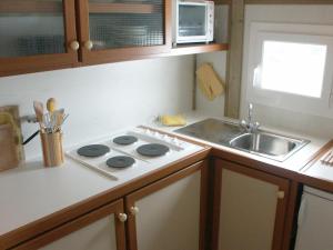 a kitchen with a stove and a sink at Chalet confortable dans espace vert avec animaux - FR-1-489-314 in Échassières