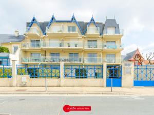 un gran edificio amarillo con adornos azules en una calle en Appartement Châtelaillon-Plage, 3 pièces, 4 personnes - FR-1-535-3, en Châtelaillon-Plage