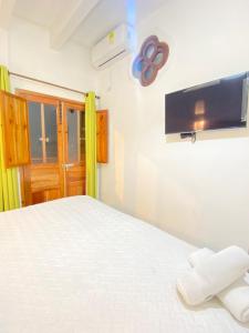 a bedroom with a bed and a tv on the wall at Patio de Getsemani in Cartagena de Indias