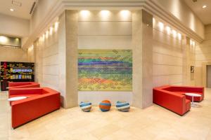 a lobby with red chairs and a basketball on the wall at Ooedo Onsen Monogatari Amakusa Hotel Kameya in Kami Amakusa