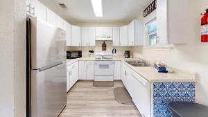 a kitchen with white cabinets and a stainless steel refrigerator at Water Haus in Fourth Crossing