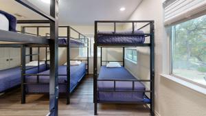 three bunk beds in a room with a window at Water Haus in Fourth Crossing