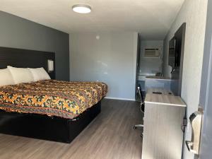 1 dormitorio con 1 cama y escritorio en una habitación en Pioneer INN, en Arkadelphia