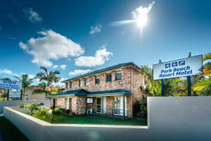 um edifício de tijolos com um sinal em frente em Park Beach Resort Motel em Coffs Harbour