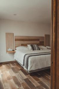 1 dormitorio con 1 cama grande y cabecero de madera en El Ciruelo, en Teziutlán